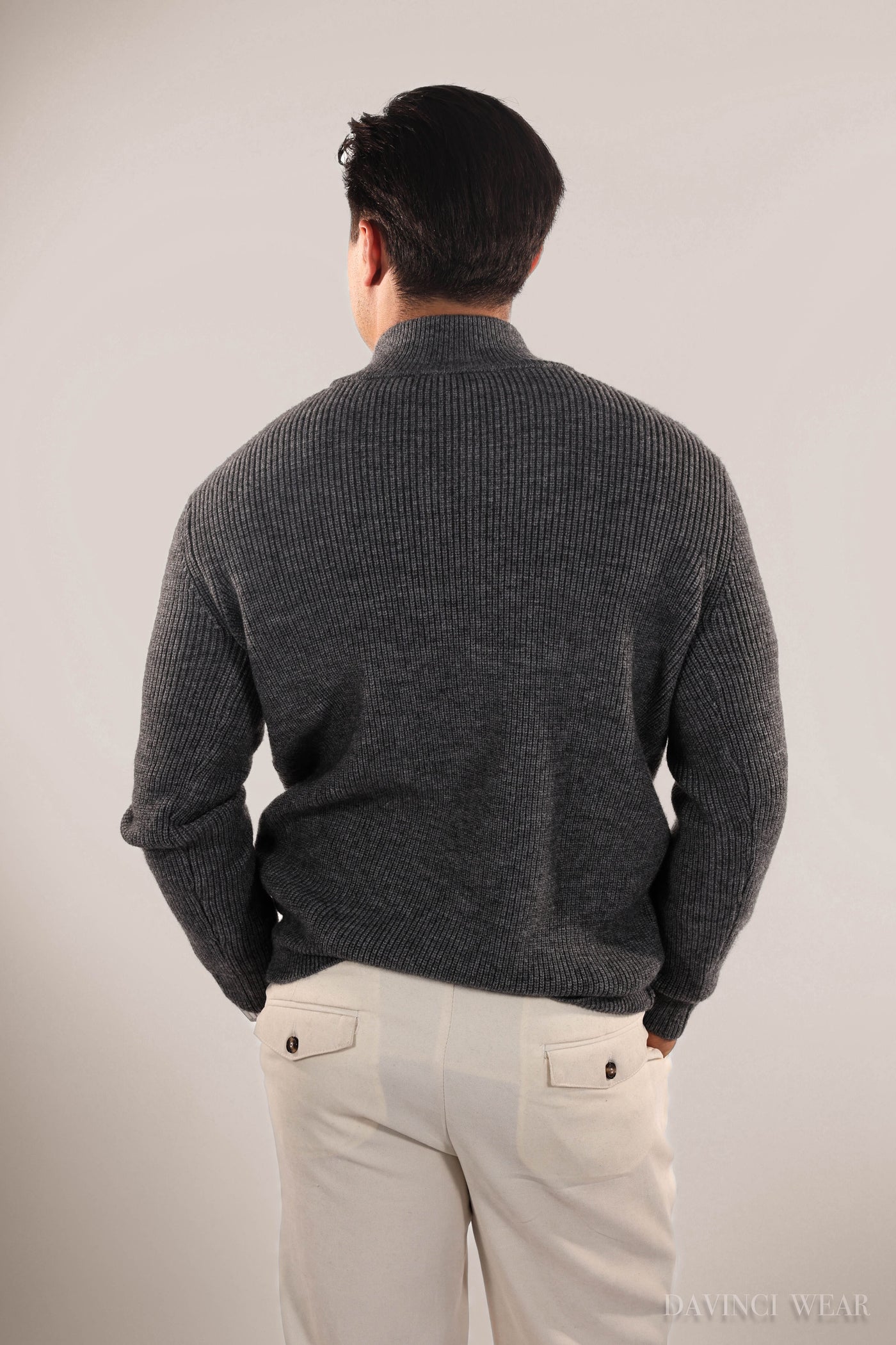 The-male-model-wears-a-black-knitted-sweater-with-back-view-and-zipper-elegant-and-cozy-design