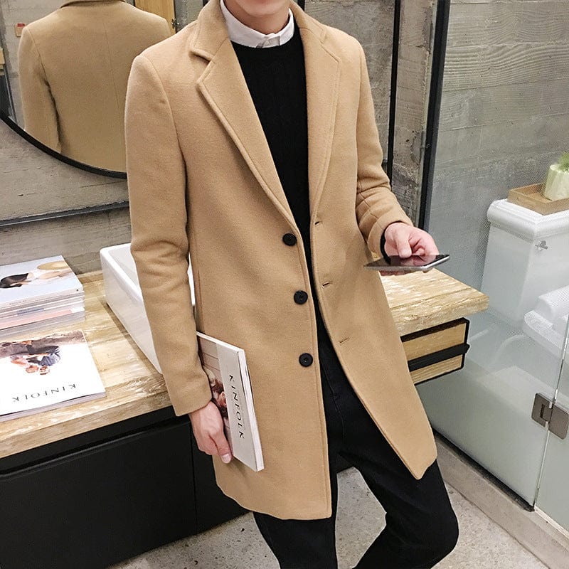 men's-long-beige-wool-coat-classic-three-button-fastener-model-stands-in-modern-interior