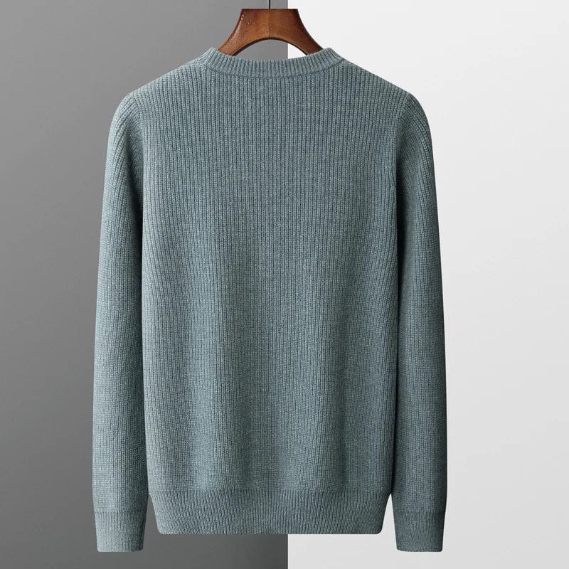 gray-cashmere-sweater-with-cable-knit-pattern-elegantly-pleated-on-a-gray-background-next-to-a-black-watch