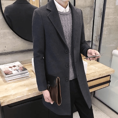 Manteau de laine gris foncé pour hommes avec fermeture à trois boutons et design classique pour une déclaration intemporelle.