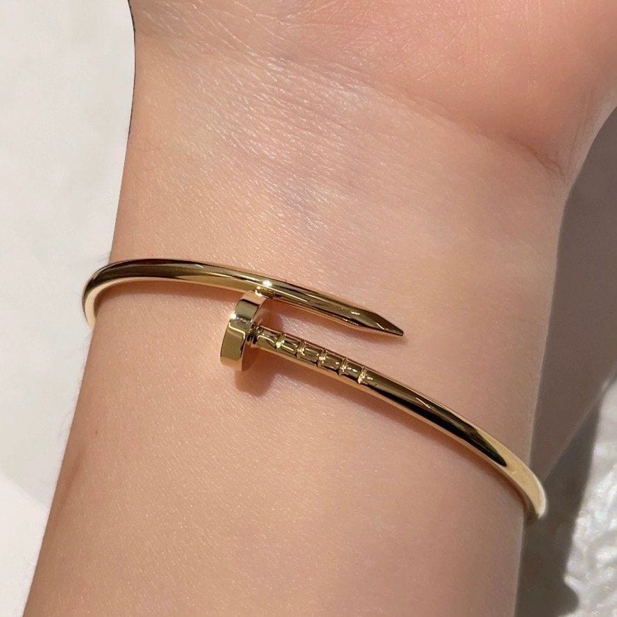 goud-roestvrij-staal-armband-in-een-nagel-ontwerp-model-stromend-tijdloos-onderkoeld-elegantie